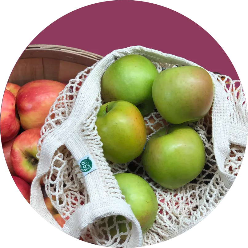a bag and crate of organic apples