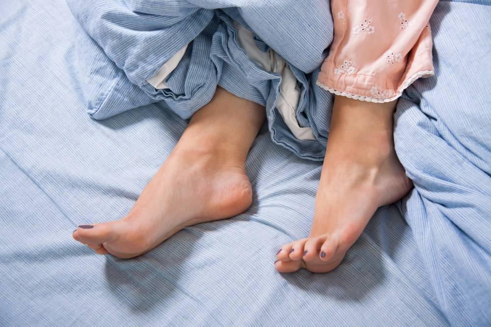 restless legs syndrome on a bed with blue sheets